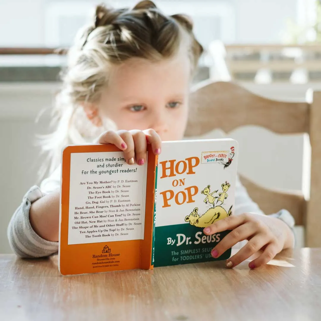 A young girl reading a Dr. Seuss Book 